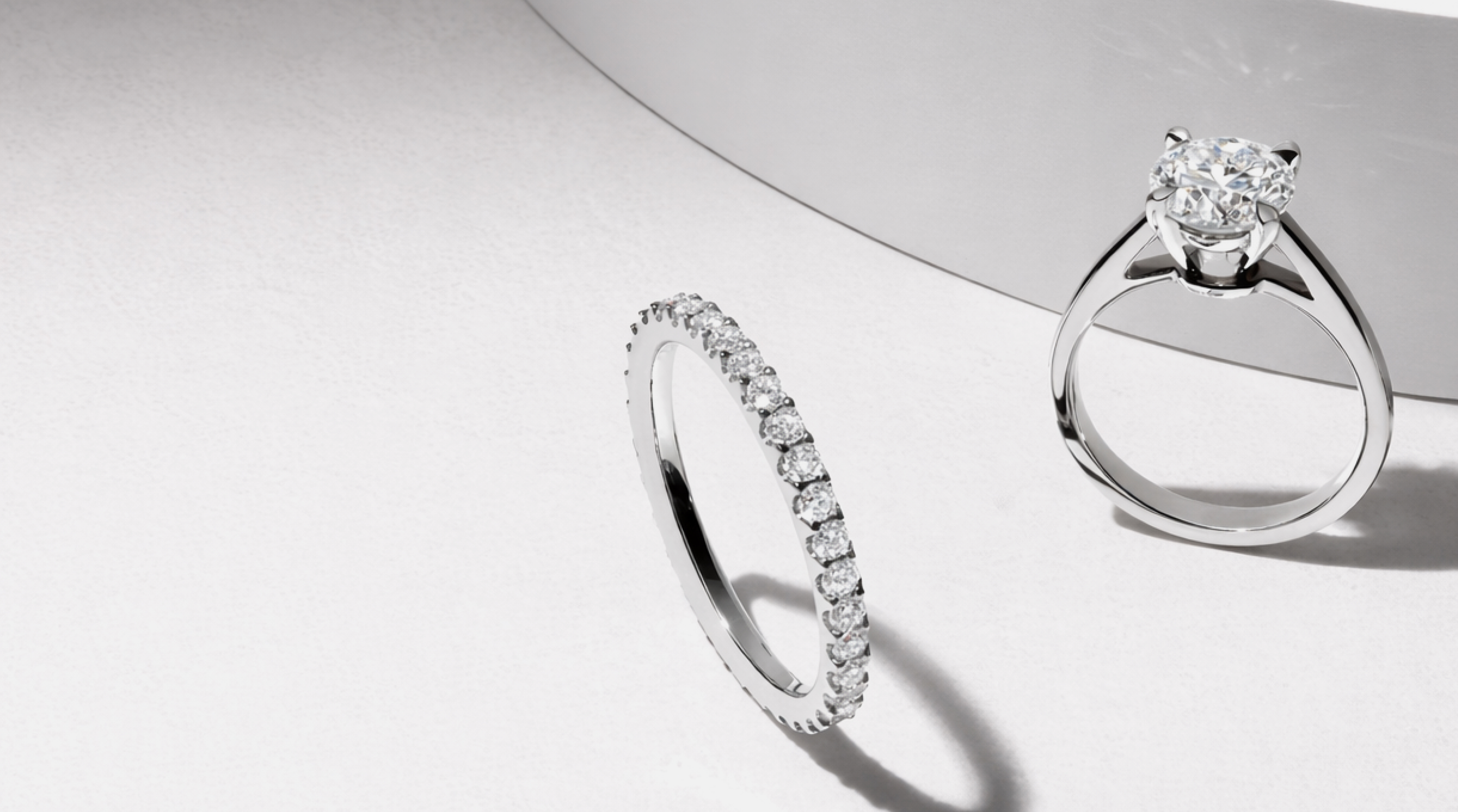Two diamond rings resting on soft fabric